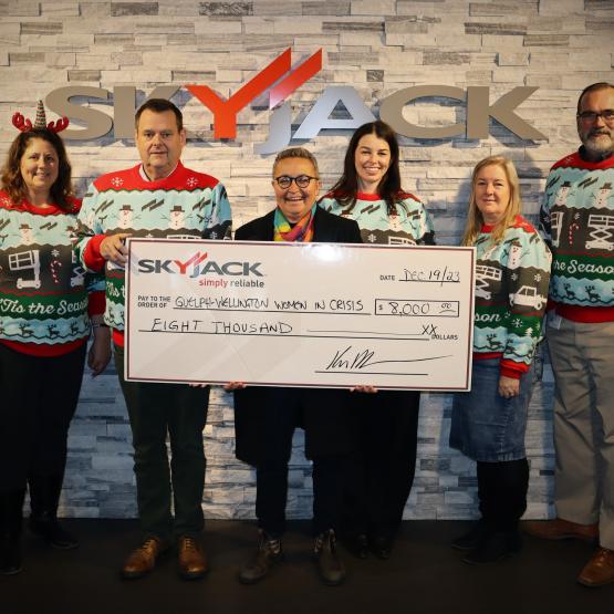 Skyjack and GWWIC members posing with the cheque in the Christmas Sweaters